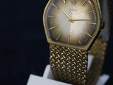 an image of a close up of a gold watch on a stand