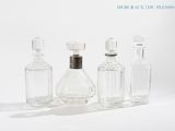 trois bouteilles en verre posées les unes à côté des autres sur une surface blanche