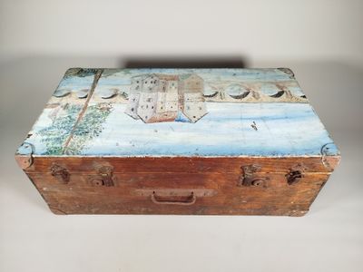 une boîte en bois décorée d'une peinture, posée sur une table