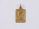 a close up of a small gold pendant on a white surface