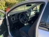 the interior of a car with the door open and the driver ' s seat up