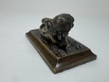bronze statue of a lion on a wooden base on a white background