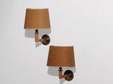 une paire d'appliques murales avec des abat-jours marron sur un mur blanc