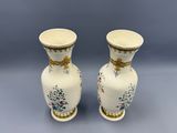 deux vases blancs ornés de motifs floraux, placés côte à côte