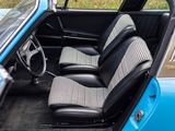 the interior of a blue car with black leather seats and a checkered seat cover