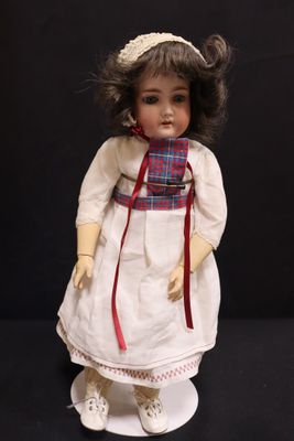 a small doll that is wearing a dress and a hat