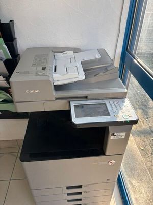 a printer sitting on top of a desk next to a window