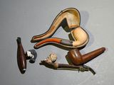 a lot of different types of smoking pipes on the table