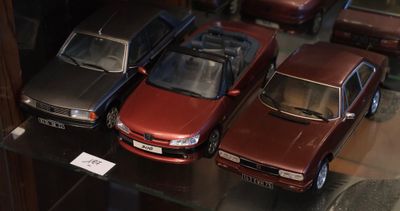 trois voitures exposées dans une vitrine