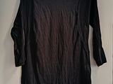 black long sleeved shirt hanging on a hanger on a wall