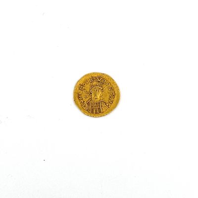 gros plan d'une pièce d'or sur une surface blanche