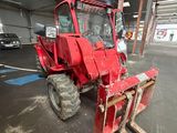 a red tractor that is parked in a garage