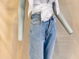 a mannequin wearing a white shirt and jeans on a stand