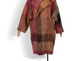 manteau en laine sur un mannequin, avec un motif à carreaux rouges et marron