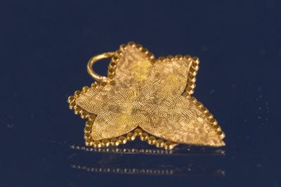 un pendentif en feuille d'or sur un fond bleu