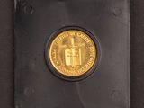 a gold coin sitting on top of a black surface
