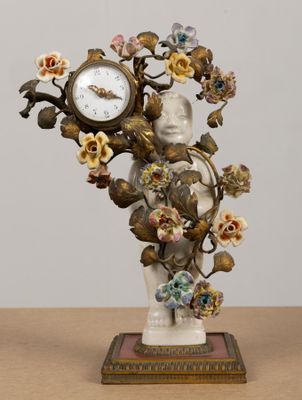 a statue of a woman holding a clock with flowers on it