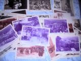 Plusieurs vieilles photos représentant des personnes et des chevaux sont exposées sur un lit