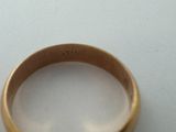 a close up of a gold ring on a white surface