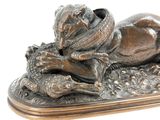 a bronze statue of a dog and a cat laying on the ground