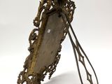 an antique brass mirror with a long handle and ornate design