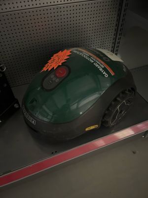 un aspirateur vert et noir posé sur une étagère dans un magasin