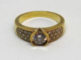 un gros plan sur une bague en or sertie d'un diamant brun et blanc