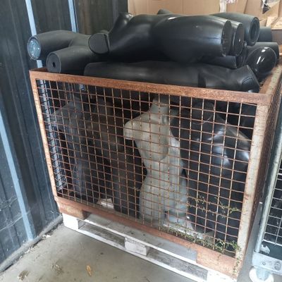 un chien dans une cage où se trouvent plusieurs bouteilles