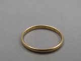 a close up of a gold wedding ring on a table