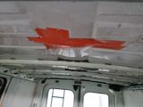 a red piece of paper taped to the ceiling of a bus