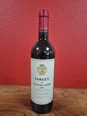 une bouteille de vin rouge posée sur une table en bois
