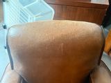a brown leather chair that is sitting in a room