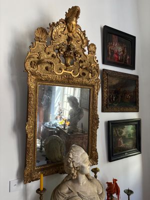 a statue of a woman sitting on a table in front of a mirror