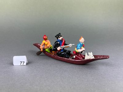 figurines of people in a boat on a gray surface