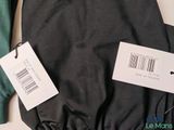 a black jacket and a green jacket with a price tag on it