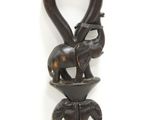 a small elephant on top of a wooden handle