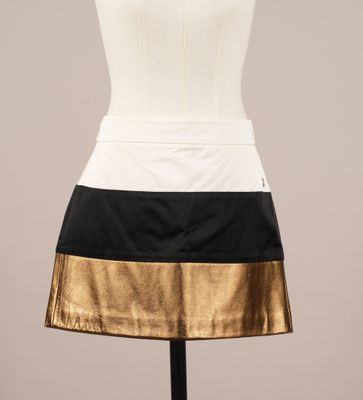 une jupe noire et blanche à rayures dorées sur un mannequin