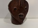 wooden sculpture of a man ' s face on a white surface