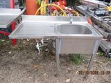 a stainless steel sink and a table in a yard