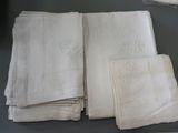 four white napkins on a table with a glass of wine