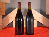 two bottles of wine sitting next to each other on a table