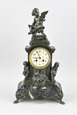 a clock with a statue on top of it on a table