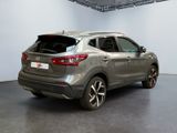 the rear end of a silver nissan qx - v parked in a showroom
