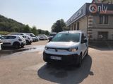 une camionnette blanche garée sur un parking devant un immeuble