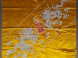 une soie jaune brodée d'un dragon et sur laquelle figure un dragon