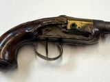 un vieux pistolet posé sur une table, avec une bague dessus