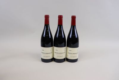 trois bouteilles de vin posées sur une table blanche