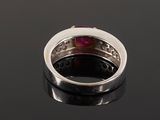 a close up of a ring with a ruby stone in it