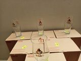 four glasses sitting on a table with boxes of wine in the background