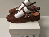 pair of brown and white shoes sitting on top of a white box